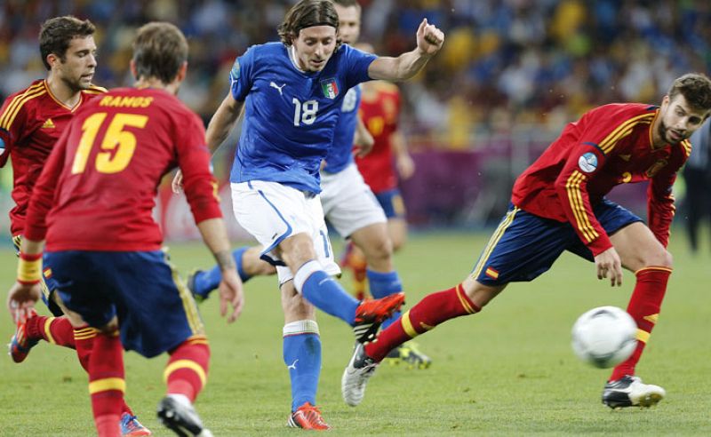 Montolivo, rodeado de los jugadores españoles, dispara un balón