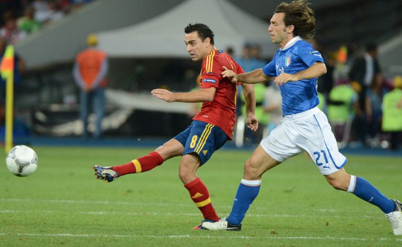 Xavi dispara ante la mirada de Pirlo