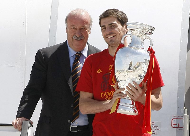El capitán Íker Casillas posa con el trofeo de la Eurocopa, junto a Vicente del Bosque, en las escalerillas del avión.