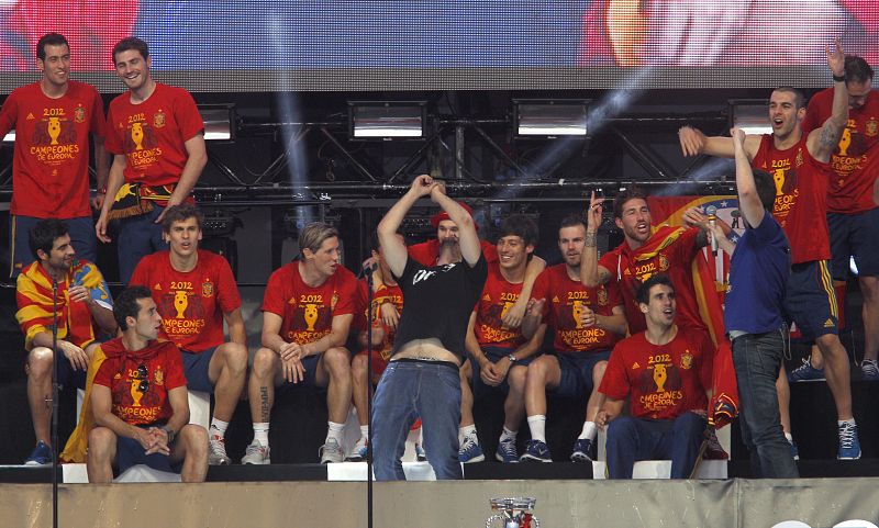 Los miembros del grupo Estopa David (c) y José (3d) cantan junto a los jugadores de la selección española en el escenario