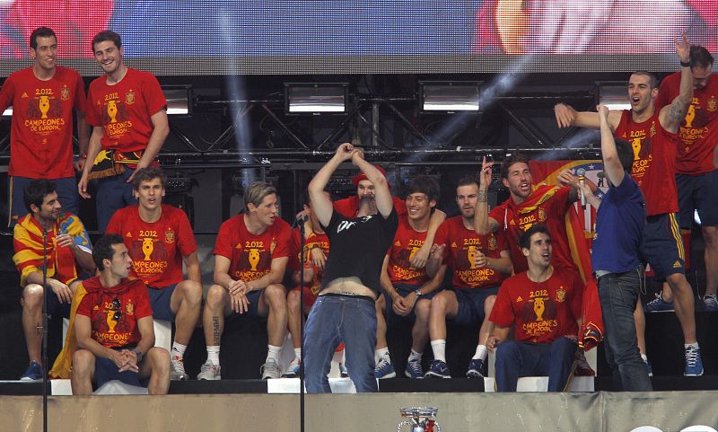 Los miembros del grupo Estopa David (c) y José (3d) cantan junto a los jugadores de la selección española en el escenario