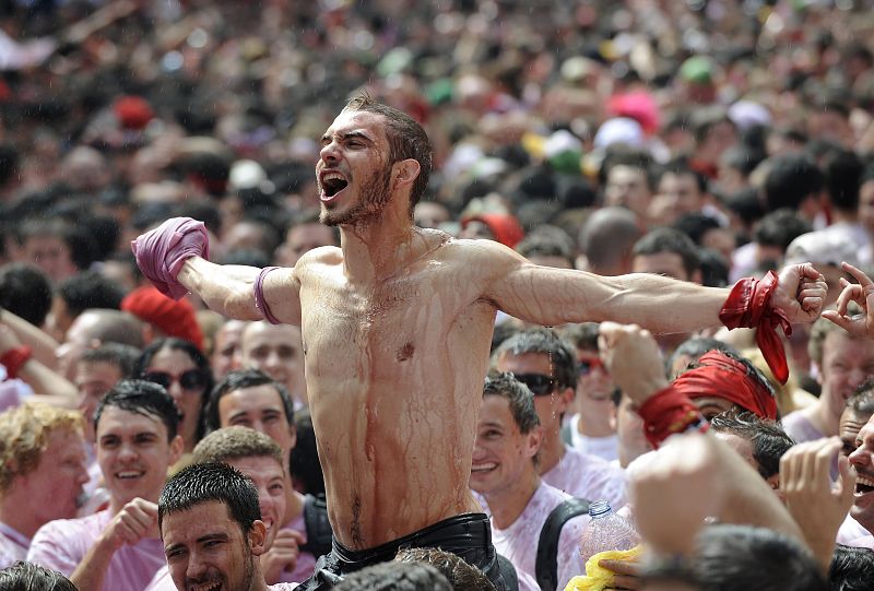 Un pamplonica sobre los hombros de sus amigos celebrando el comienzo de los Sanfermines