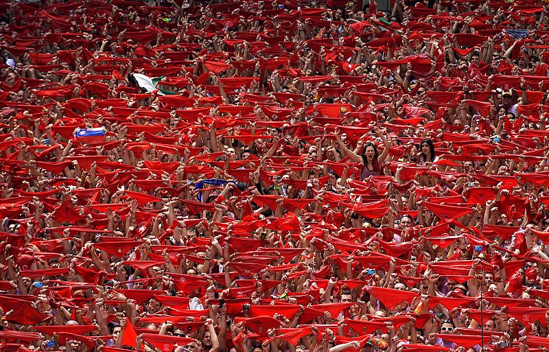Los asistentes al Chupinazo elevan sus pañuelos rojos al cielo