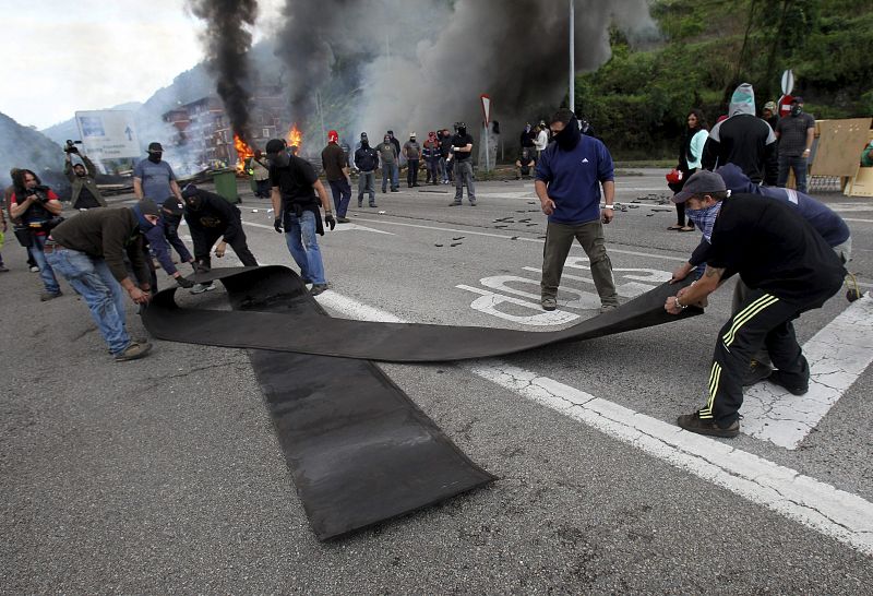 Los mineros que cortan con una barricada colocada junto al pozo Santiago el tráfico desde primera hora de la mañana realizan un lazo negro