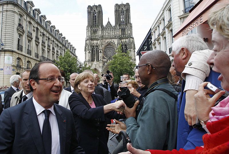 France's President Hollande and Germany's Chancellor Merkel shake hands with the crowd in Reims