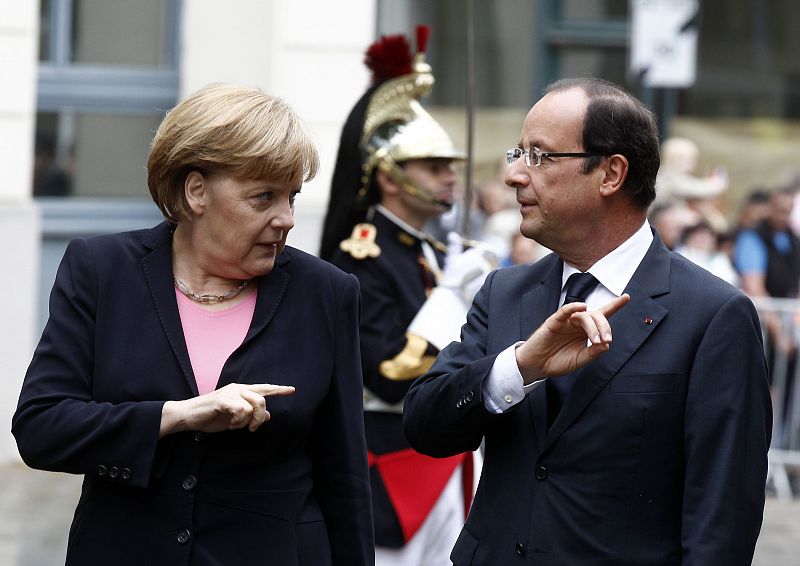 France's President Hollande listens to Germany's Chancellor Merkel as they attend the 50th anniversary ceremony of a reconciliation meeting in Reims
