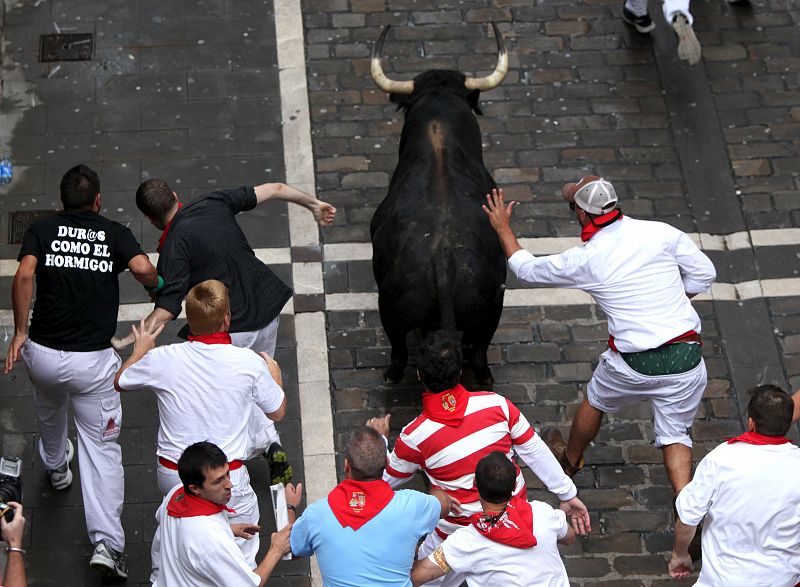 Los mozoz corren detrás de un toro rezagado