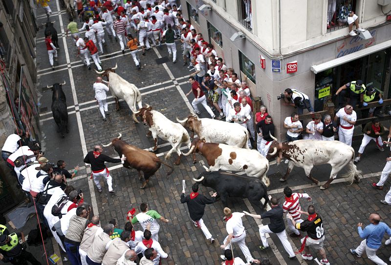 Los toros y los mozos en la curva de mercaderes