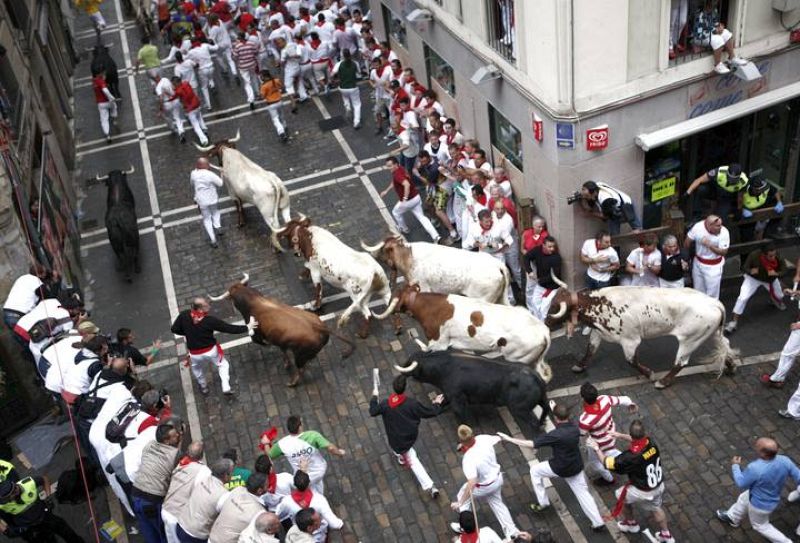 Los toros y los mozos en la curva de mercaderes