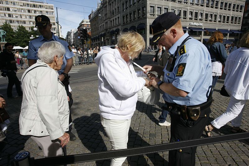 Security personnel check a woman's bag on her way to a memorial service in Oslo Cathedral
