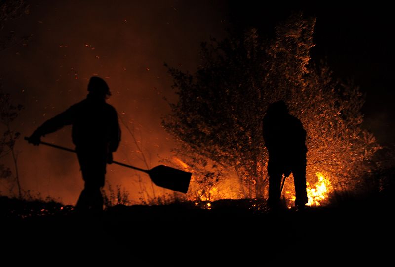 Los bomberos luchan contra las llamas durante la noche
