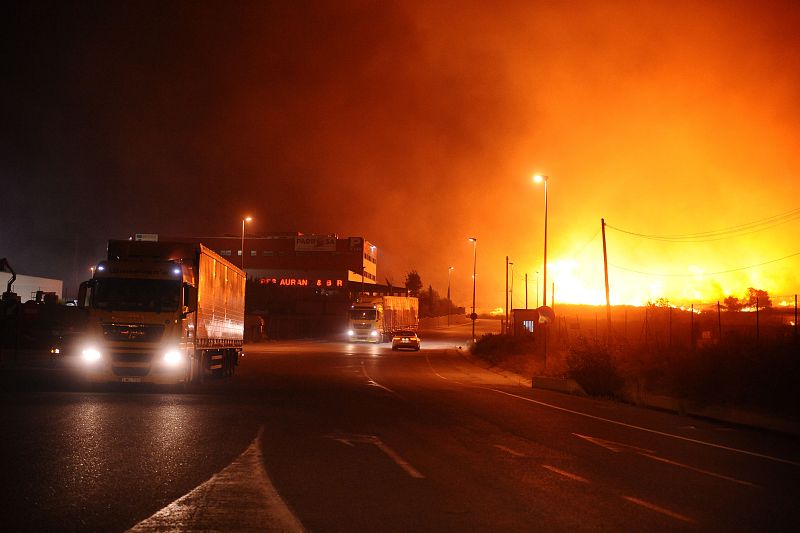 Vehiculos circulan por una carretera cercana al incendio en el que ya se han restablecido las conextiones por francia en la autopista AP7 en sentido norte y en la linea de tren convencional