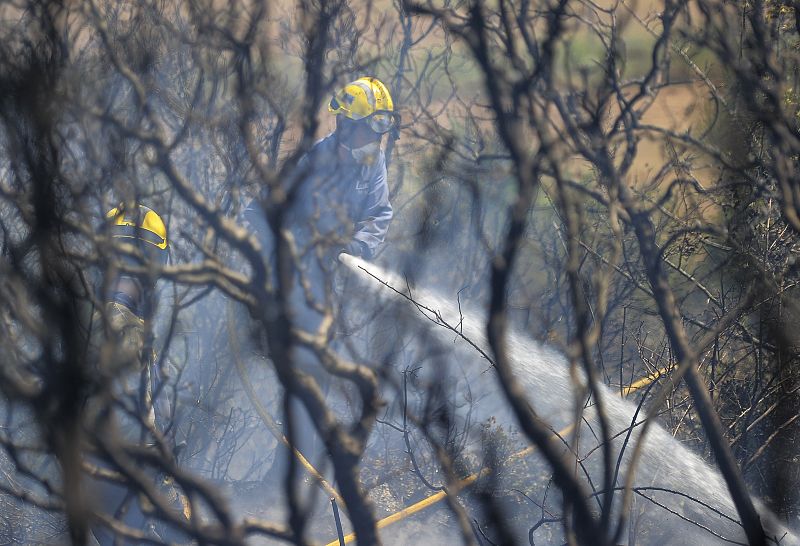 Un bombero trabaja para extinguir uno de los fuegos en el incendio de Girona.