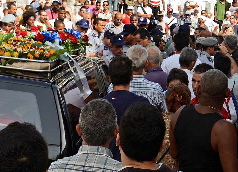 Partidarios y opositores del Gobierno acompañan el coche fúnebre que lleva los restos mortales de Payá.