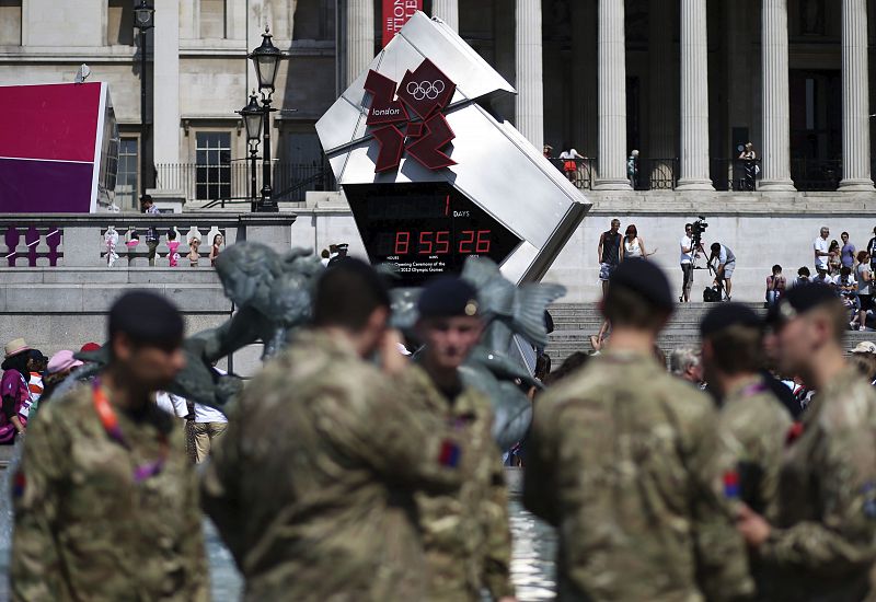 Unos soldados británicos miran en Trafalgar Square hacia el reloj que muestra la cuenta atrás para el comienzo de los Juegos Olímpicos de Londres 2012 en Londres.