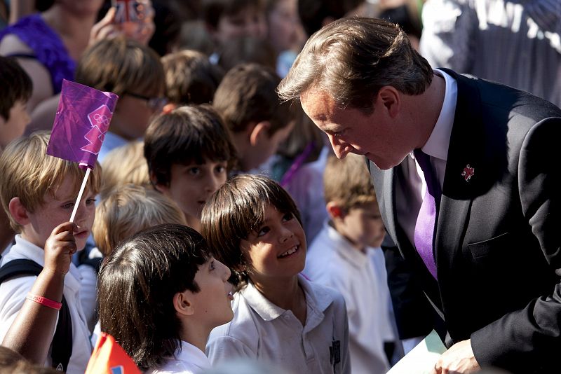 El primer ministro británico David Cameron conversa con un grupo de niños mientras espera la llegada de la antorcha olímpica al número 10 de Downing street en Londres.