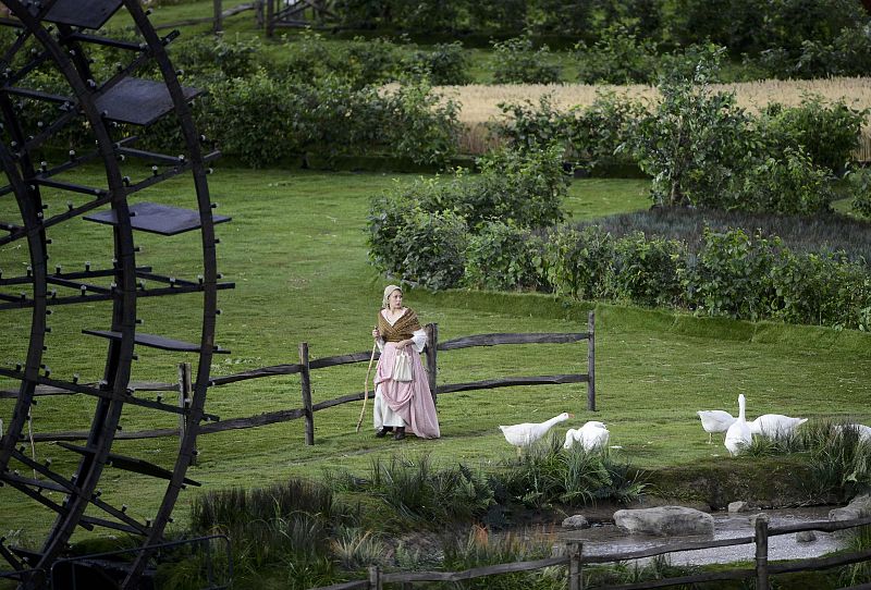 An actress walks during a scene showing a pre industrial rural England during the opening ceremony of the London 2012 Olympic Games at the Olympic Stadium