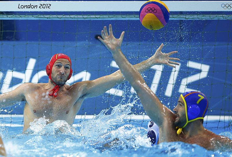 Spain's goalkeeper Daniel Lopez Pinedo dives to save a shot next to Spain's Blai Mallarach Guell during their men's preliminary round Group A water polo match at the Water Polo Arena during the London 2012 Olympic Games