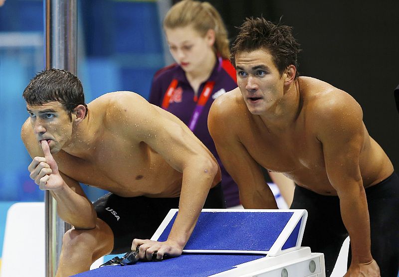 Michael Phelps and Nathan Adrian of the U.S. watch a swimmer during the men's 4x100m freestyle relay final during the London 2012 Olympic Games at the Aquatics Centre