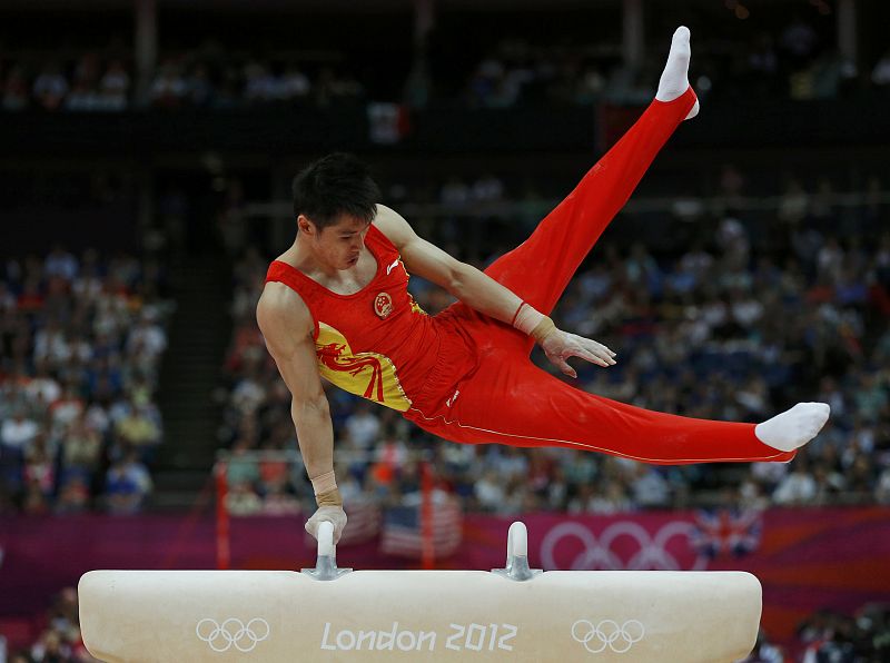 El gimnasta chino Zhang Chenglong completa el ejercicio de potro; el equipo chino ha logrado el oro en la final masculina de gimnasia artística.