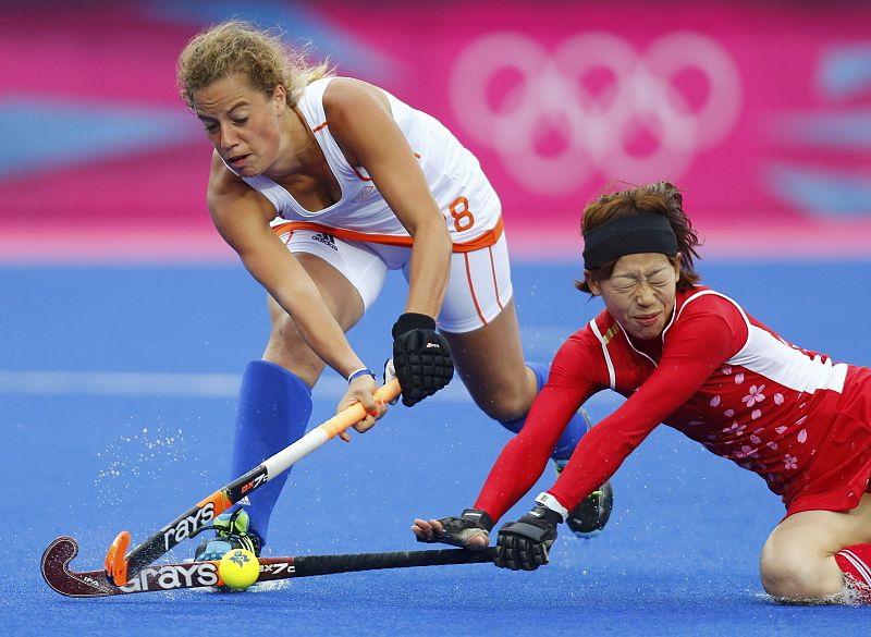 La holandesa  Merel de Blaeij y la japonesa Kaori Fujio pelean durante el partido de hockey.
