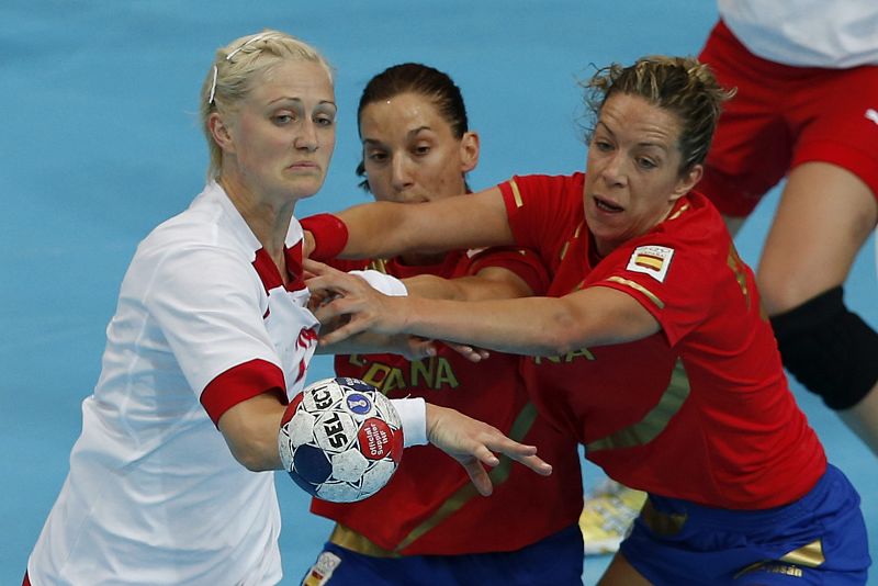 La jugadora de la selección española Andrea Barno (c) defiende a la jugadora de Dinamarca Rikke Skov (i), en partido de la fase de grupos del torneo olímpico de balonmano que se disputa en el Copper Box de Londres.