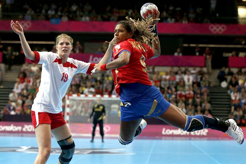 La jugadora de la selección española Marta Mangué (d) intenta superar a la jugadora de Dinamarca Line Jorgensen, en partido de la fase de grupos del torneo olímpico de balonmano que se disputa en el Copper Box de Londres.