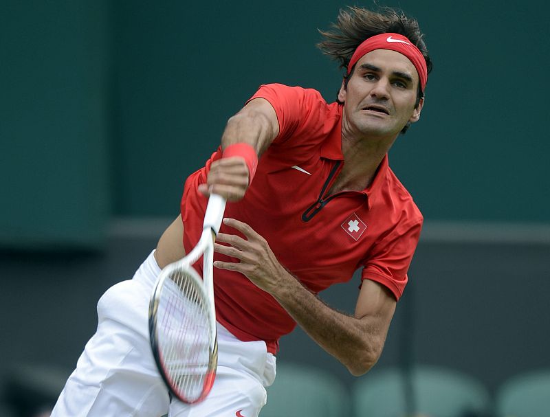 El tenista suizo Roger Federer le devuelve la bola al estadounidense John Isner durante el partido de cuartos de final de los Juegos Olímpicos Londres 2012, en Wimbledon.