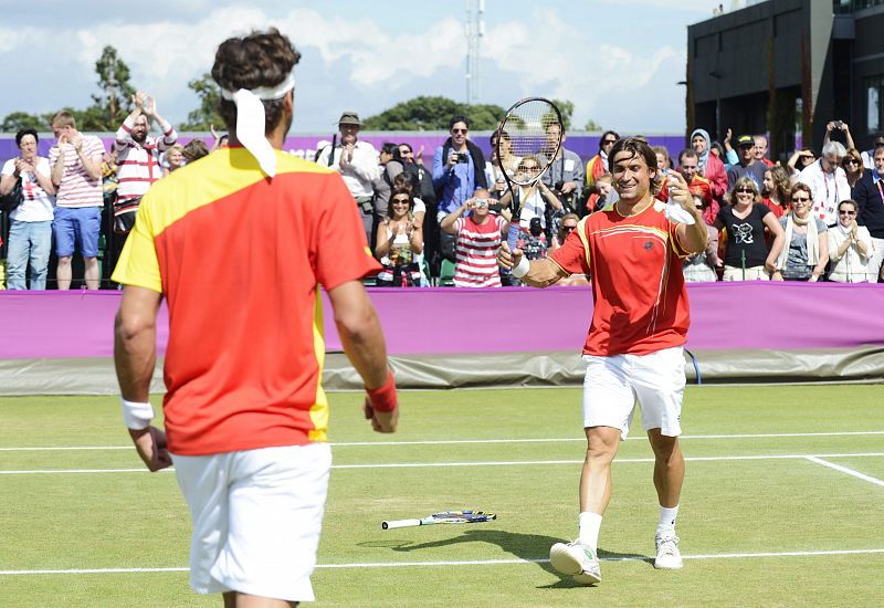Los tenistas españoles David Ferrer (d) y Feliciano López (i) celebran su triunfo en el partido de dobles de cuartos de final de los Juegos Olímpicos de Londres 2012 que disputaron contra la pareja de croatas Cilic/Dodig en Wimbledon.