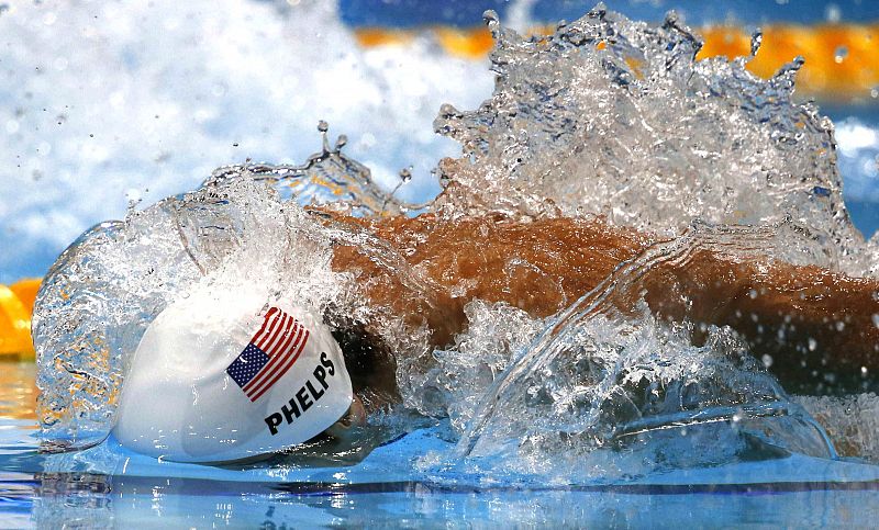 El estadounidense Michael Phelps compite en su serie de 100 mariposa.