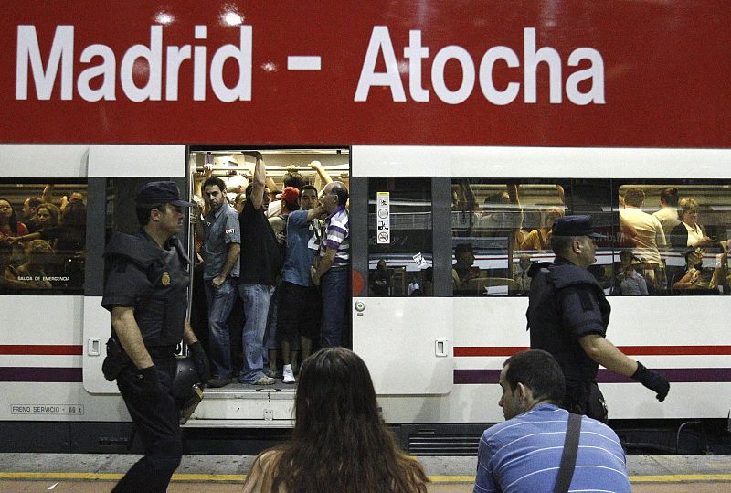 Agentes de la Policia Nacional vigilan un anden en la estacion de Atocha a primeras horas de la mañana