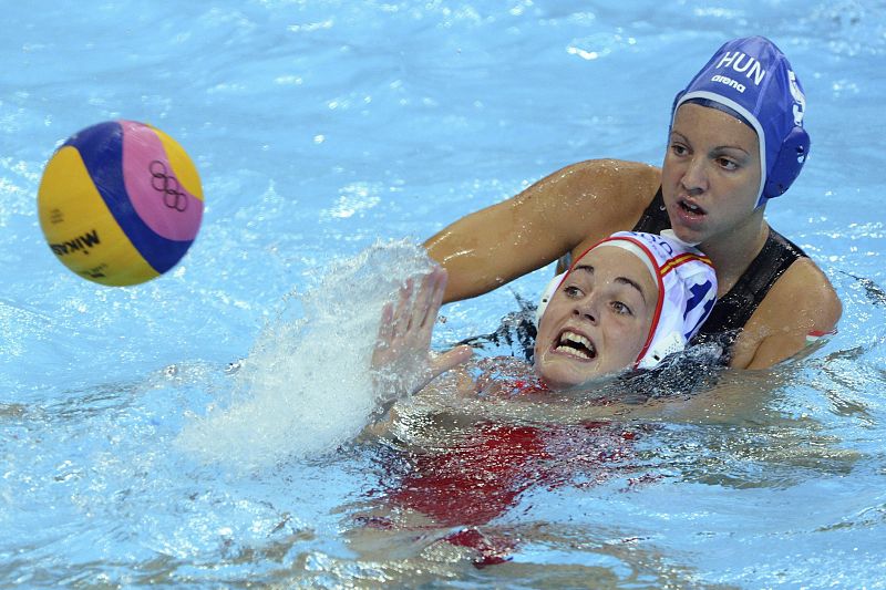 La española Maica Garcia (gorro blanco) pierde el balón tras la confrontación con Ildiko Toth de Hungría (gorro azul) en el partido de Waterpolo de la tercera ronda en los JJ.OO de Londres 2012 en el Centro Acuático de Londres.