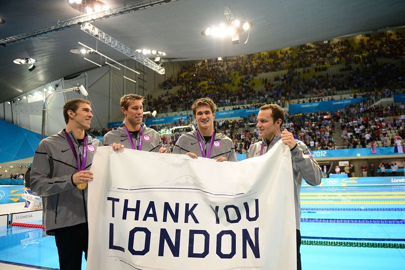 Matthews Grevers, Brendan Hansen, Michael Phelps y Adrian Nathan, oro en 4x100 metros estilos representando a EE.UU., sostienen una pancarta en la que reza: Gracias, Londres.