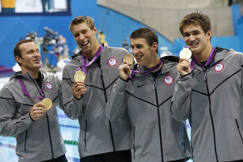 El nadador estadounidense Michael Phelps (2d), junto a sus compañeros Natan Adrian (d) Brendan Hansen (2i) y Matthew Grevers, tras ganar la medalla de oro en la prueba de los 4x100 estilos.