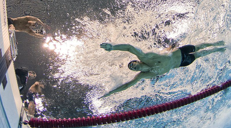 Michael Phelps (d) compite mientras le espera Nathan Adrian en la final de los 4x100.