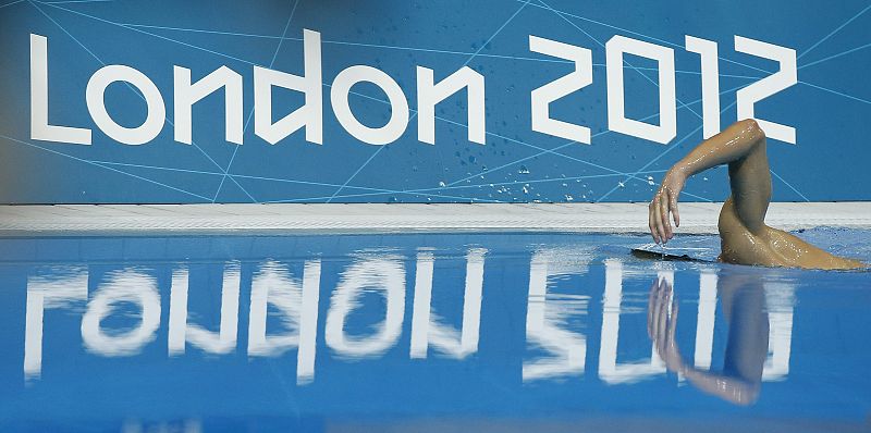 Michael Phelps, medalla de oro, se lanza a la piscina tras la prueba de 200 metros estilos.