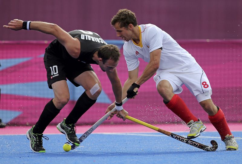 Belgium's Florent van Aubel is challenged by New Zealand's Ryan Archibald during their men's group B hockey match at Riverbank Arena at the London 2012 Olympic Games