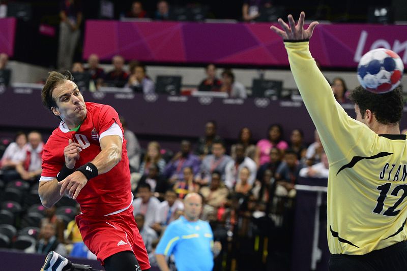 El jugador húngaro Gergely Harsanyi (L) dispara con la derecha para anotar frente al portero serbio Stanic Darko (R) durante el partido de balonmano Hungría vs Serbia en la ronda preliminar del grupo B.