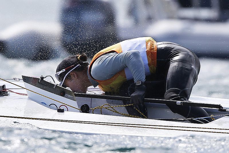 La china Lija Xu besa su embarcación tras cruzar la meta y ganar el oro en la clase Láser Radial femenina, en aguas de Weymouth, sede olímpica de vela.