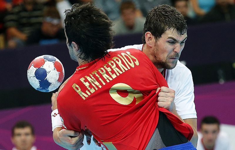 El español Raúl Entrerrios es obstaculizado por un jugador croata durante el partido del torneo olímpico de balonmano que enfrentaron a las selecciones de España y Croacia.
