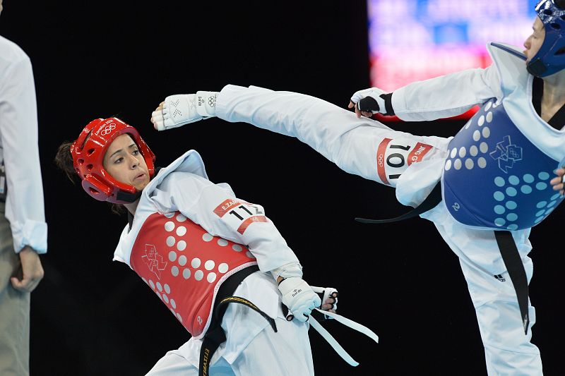 Elizabeth Zamora Gordillo de Guatemala (L) lucha contra Wu Jingyu China durante la ronda preliminar de mujeres en la categoría 49 kg, de taekwondo.