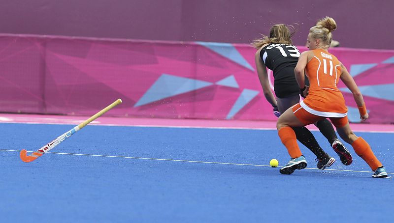 La jugadora holandesa Maartje Goderie pelea por la bola con la neozelandesa Samantha Charlton durante la semifinal femenina de hockey, jugada en el Riverbank Arena de Londres.