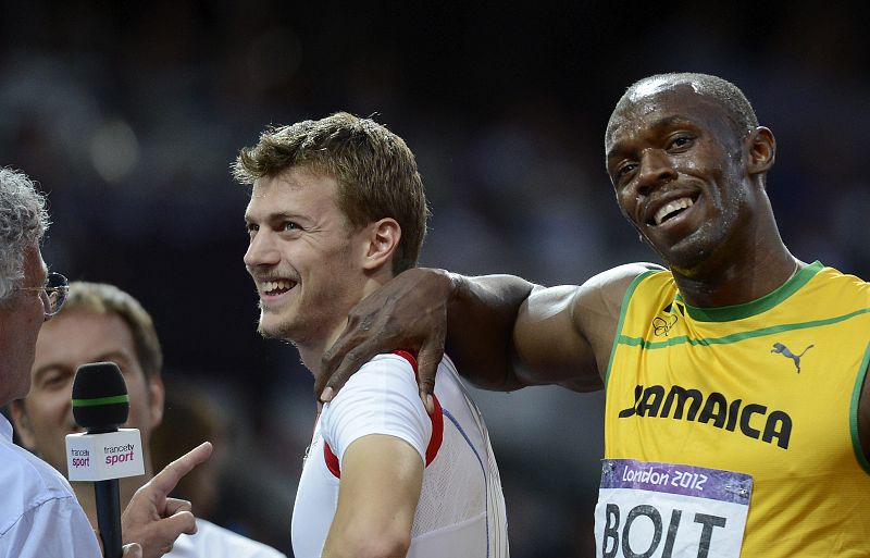 El atleta jamaicano Usain Bolt bromea con el francés Christophe Lemaitre tras las semifinales de los 200m masculinos.