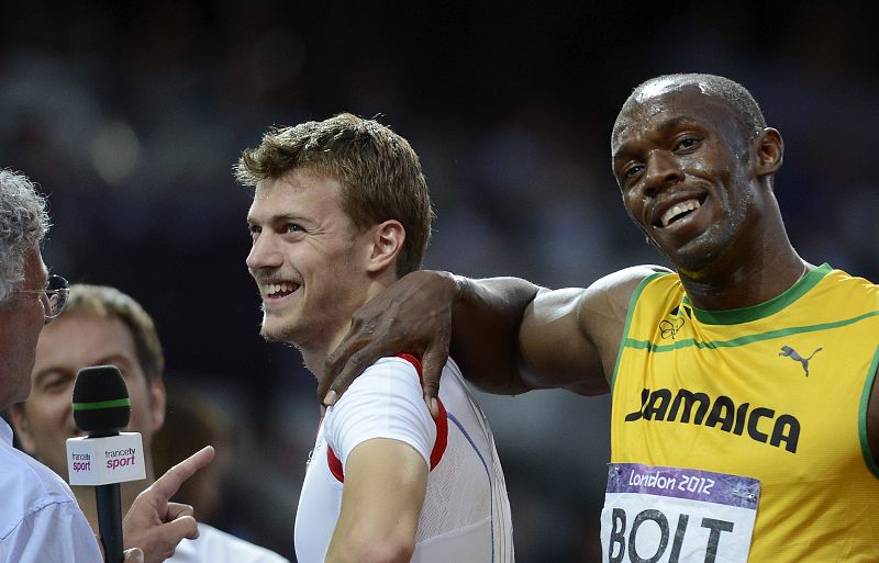 El atleta jamaicano Usain Bolt bromea con el francés Christophe Lemaitre tras las semifinales de los 200m masculinos.