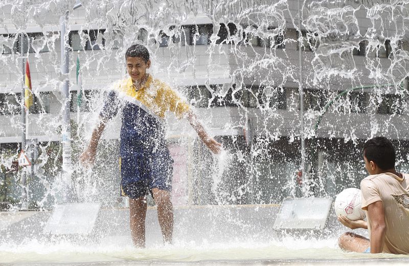 Jovenes se refrescan en una fuente de Cordoba