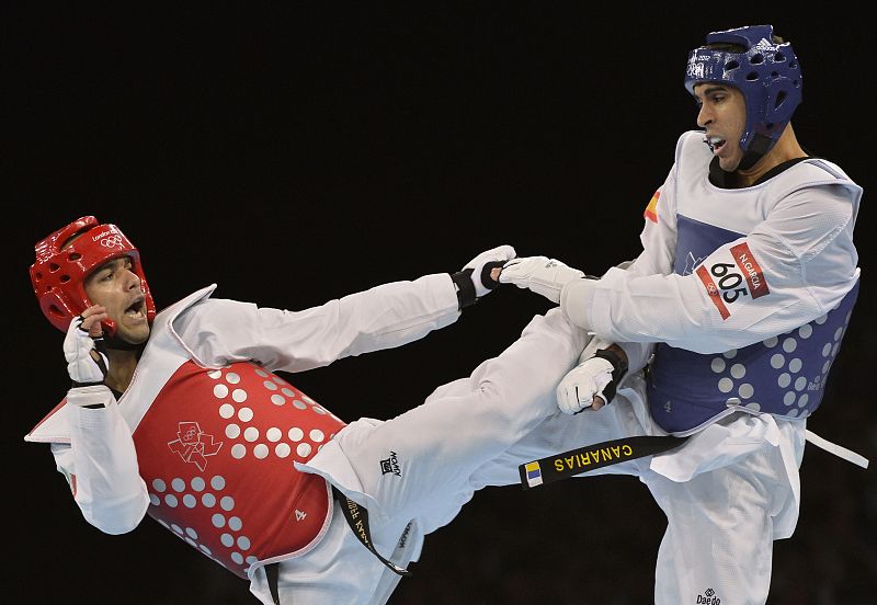 El español Nicolás García  pelea contra el iraní Yousef Karami (rojo) durante la clasificación para cuartos de final masculina de taekwondo en la categoría de menos de 80 kg.