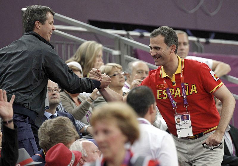 El principe Felipe saluda a Federico de Dinamarca, en las gradas del North Greenwich Arena, donde las selecciones de España y EE.UU. de baloncesto se enfrentan en la final olímpica por la medalla de oro.