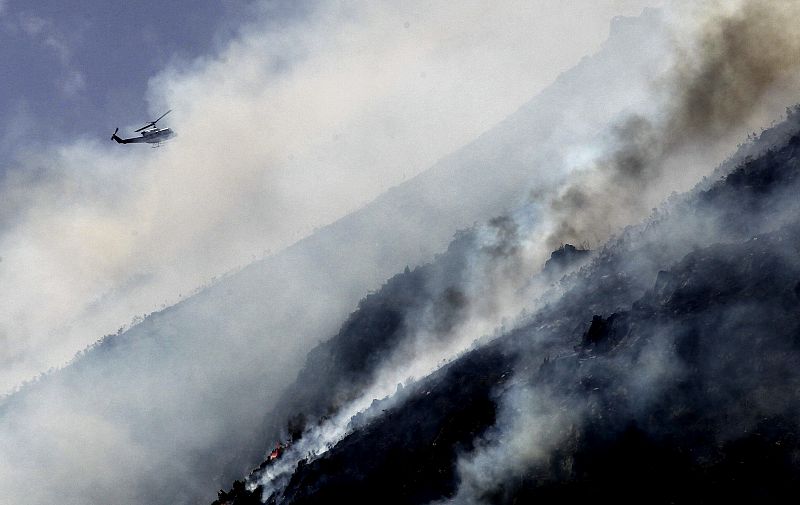 Un helicoptero trabaja en las labores de extincion del incendio forestal declarado en el termino municipal de Palacios de Sil, en la cuenca del Alto Sil, en Leon