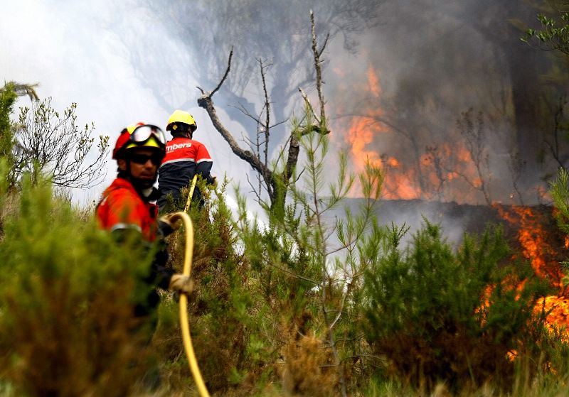 Dos bomberos intentan apagar el fuego en el termino alicantino de La Torre de les Maçanes