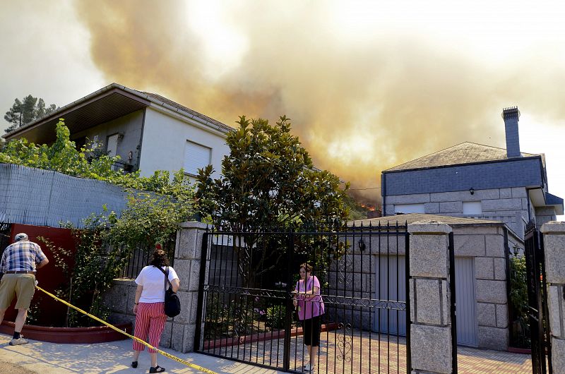 Unos vecinos de A Veiga de Cascalla abandonaban su casa en la tarde del sabado 11 ante el incendio iniciado en O Barco de Valdeorras, en Ourense